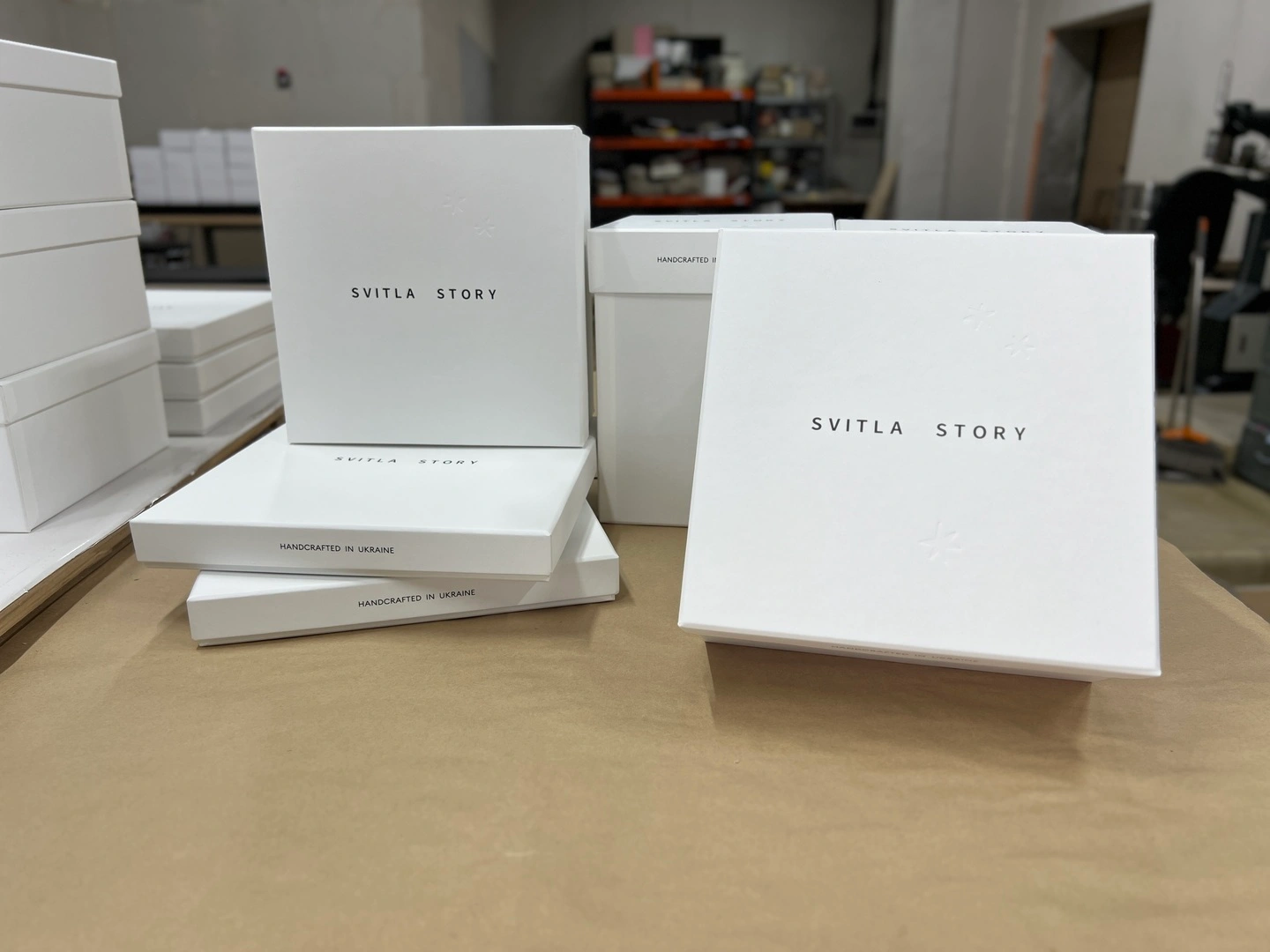 White lid-bottom boxes for ceramic products with Svitla Story logo