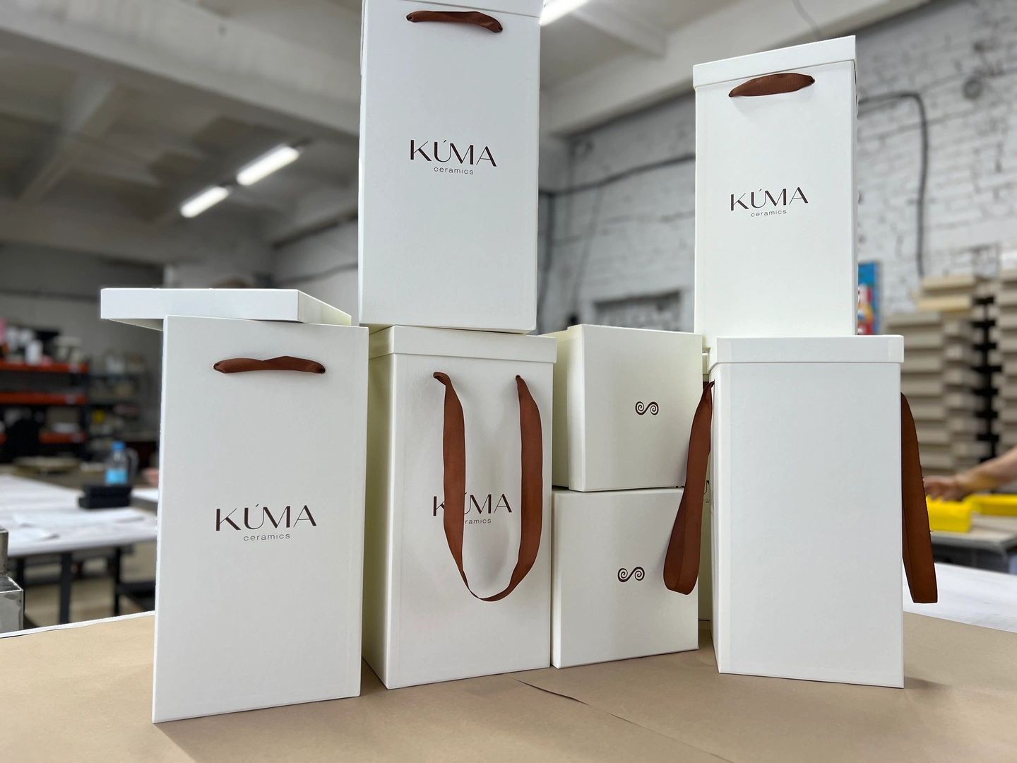 White lid-bottom boxes with handles for packaging vases with the KUMA logo