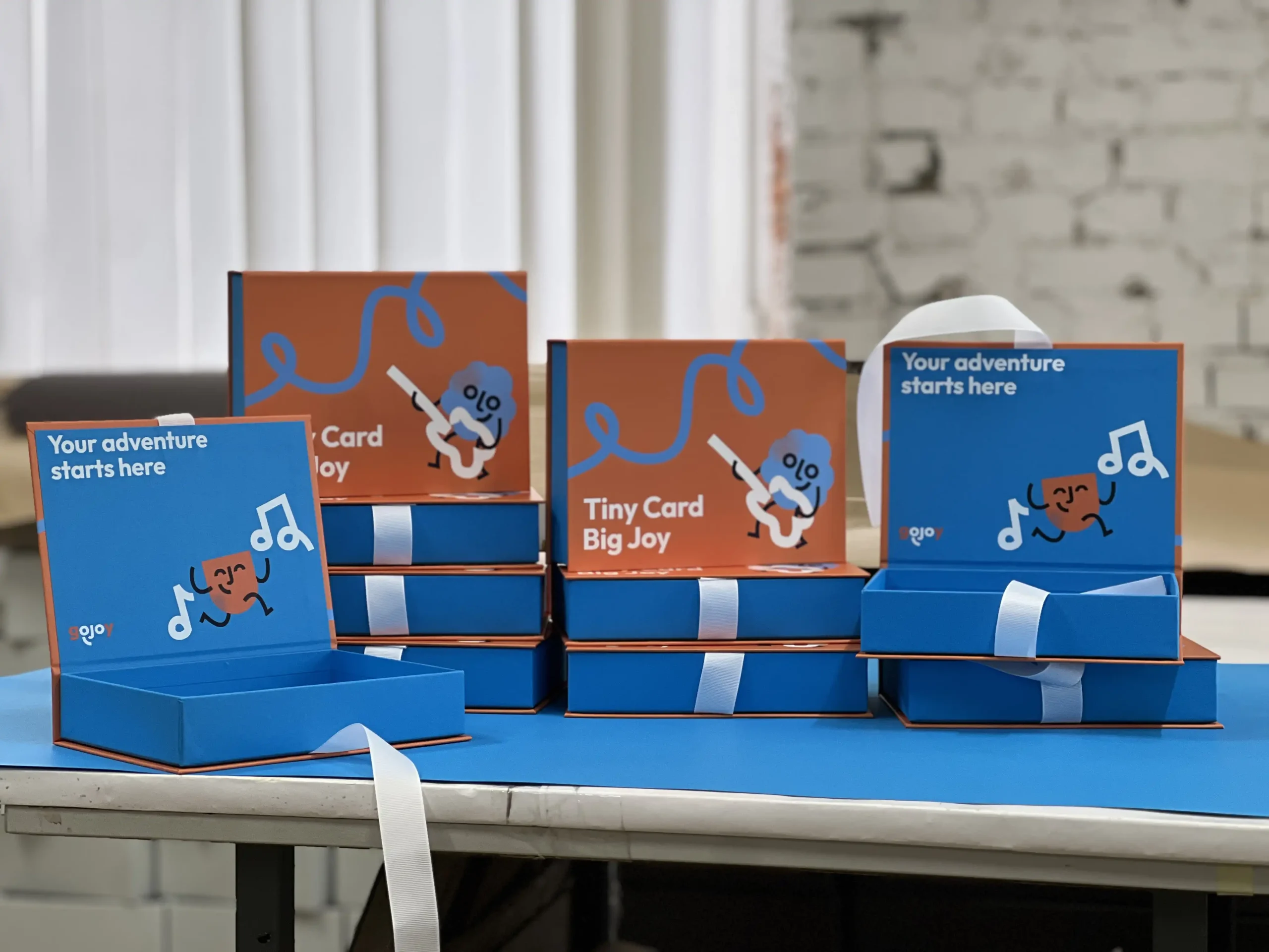 Production of durable packaging for gojoy playing cards. Featuring sturdy cardboard, functional ribbon closure, full-color and silk screen printing.