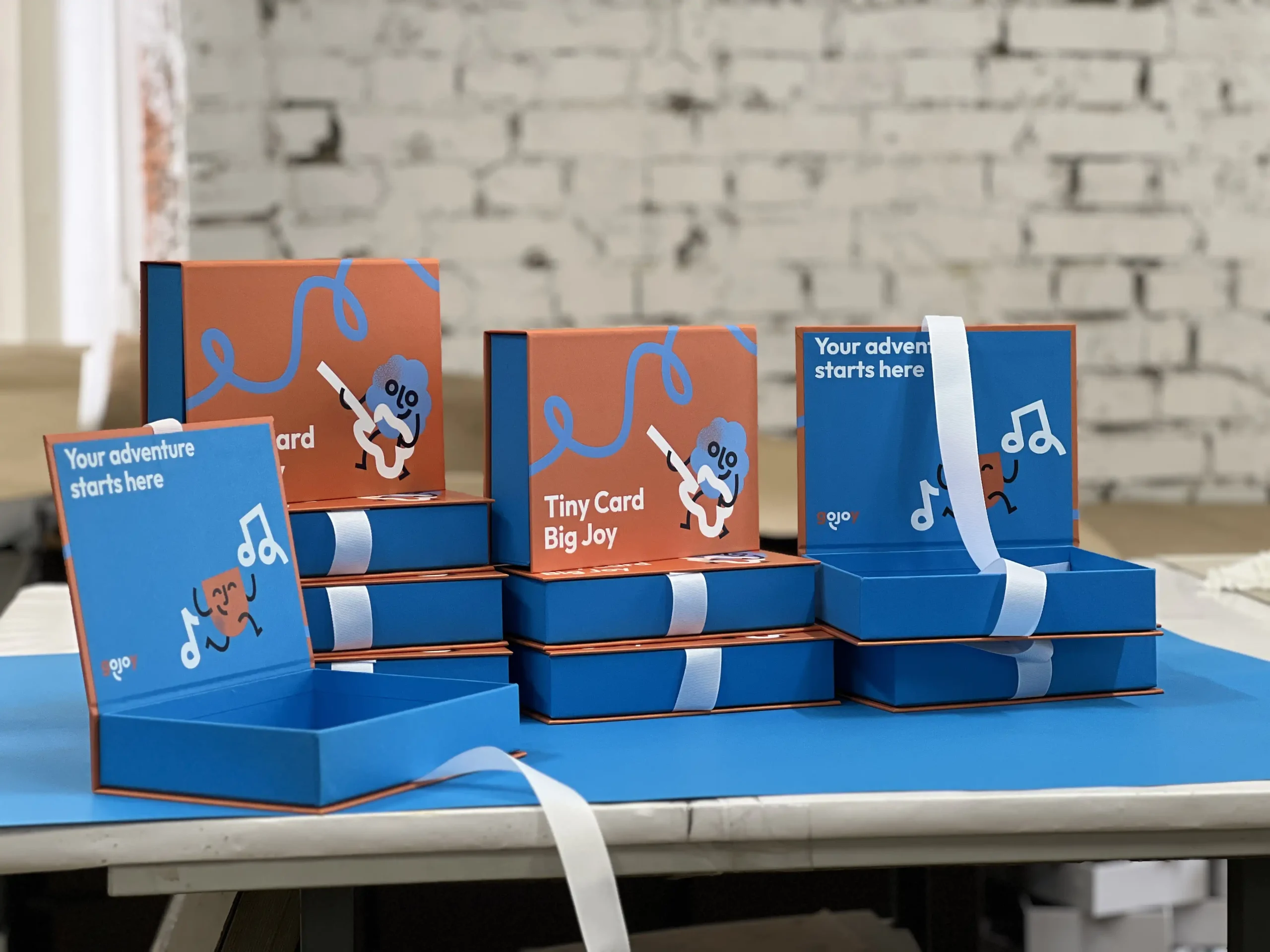 Production of durable packaging for gojoy playing cards. Featuring sturdy cardboard, functional ribbon closure, full-color and silk screen printing.