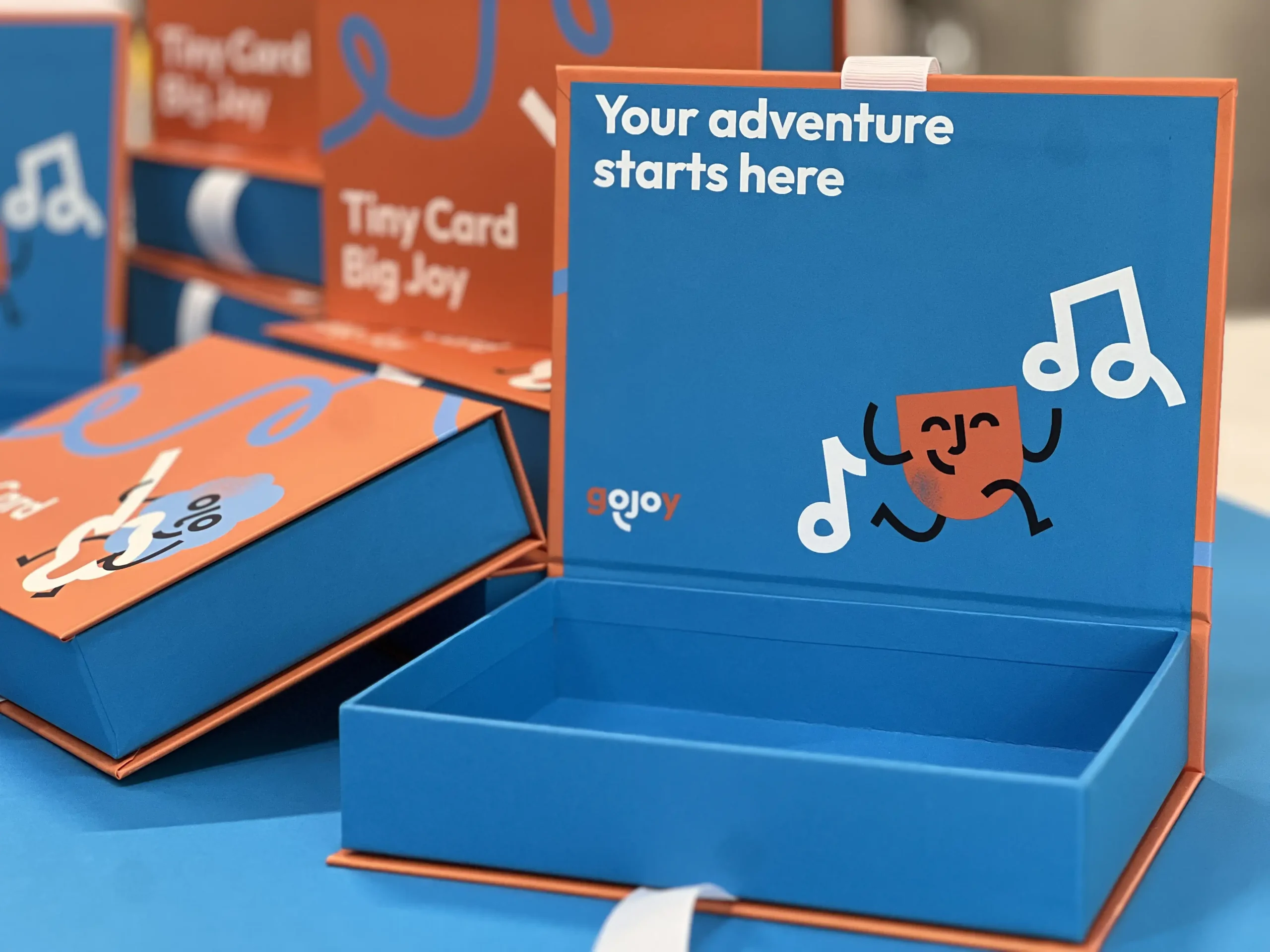 Production of durable packaging for gojoy playing cards. Featuring sturdy cardboard, functional ribbon closure, full-color and silk screen printing.