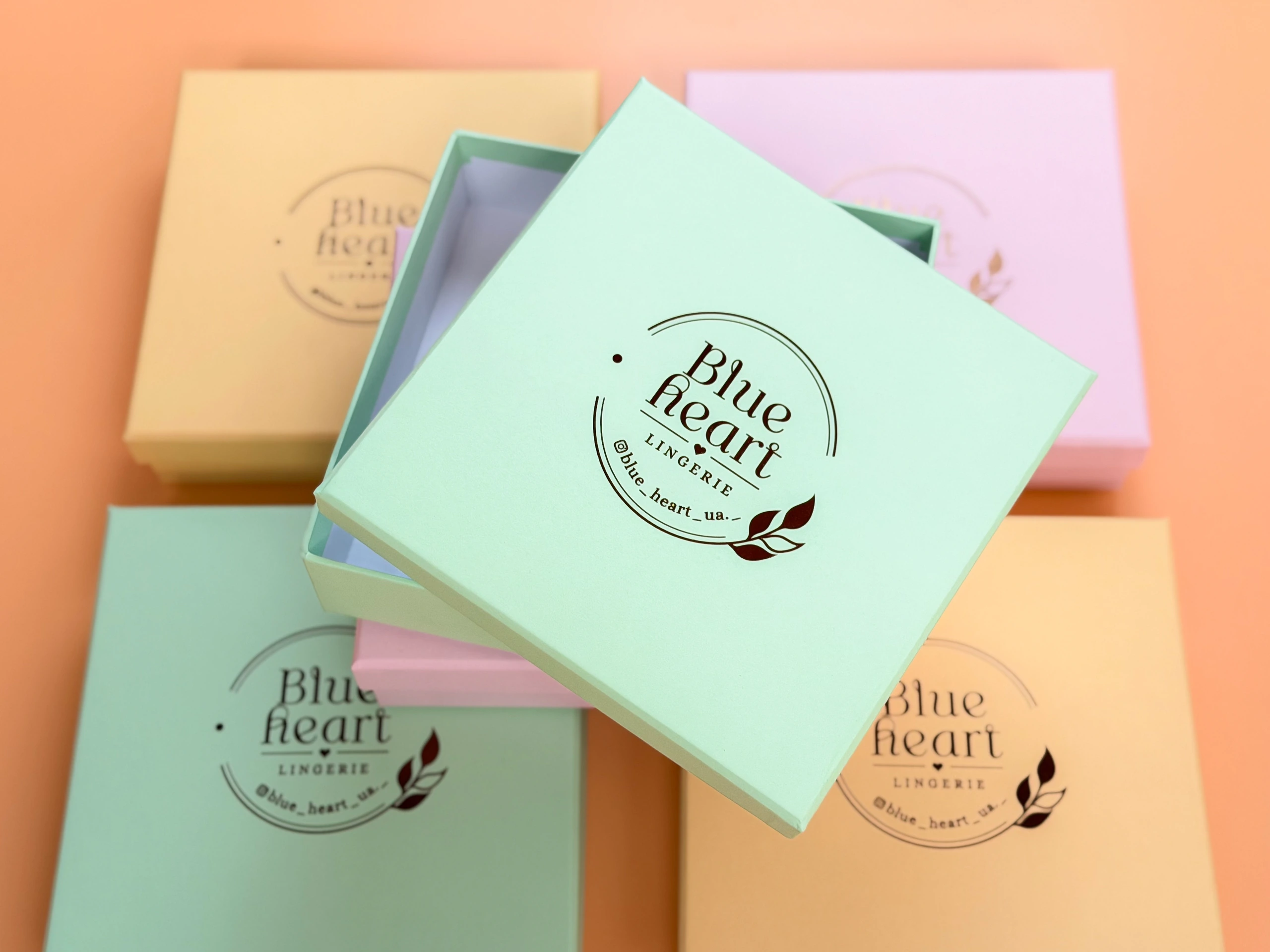 М'ятна коробка Blue Heart з логотипом мідною фольгою серед коробок інших кольорів