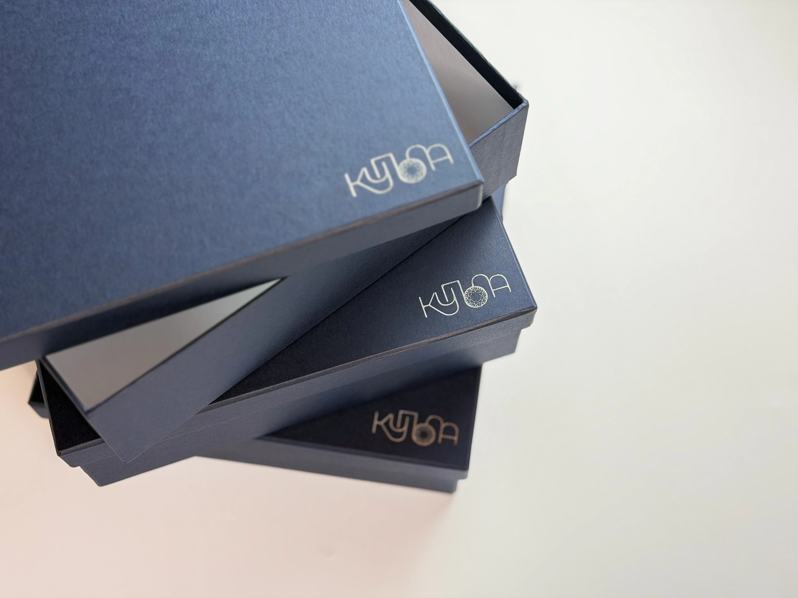 Три коробки для книжок Купола одна на одній зі срібним логотипом